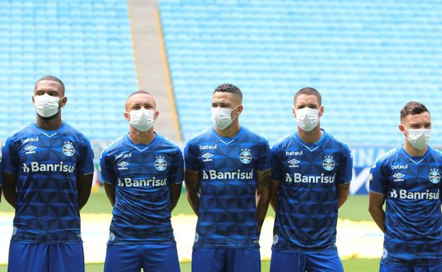 Los jugadores del Grêmio entran en el campo con máscaras al obligarles a jugar en la liga de Brasil. 