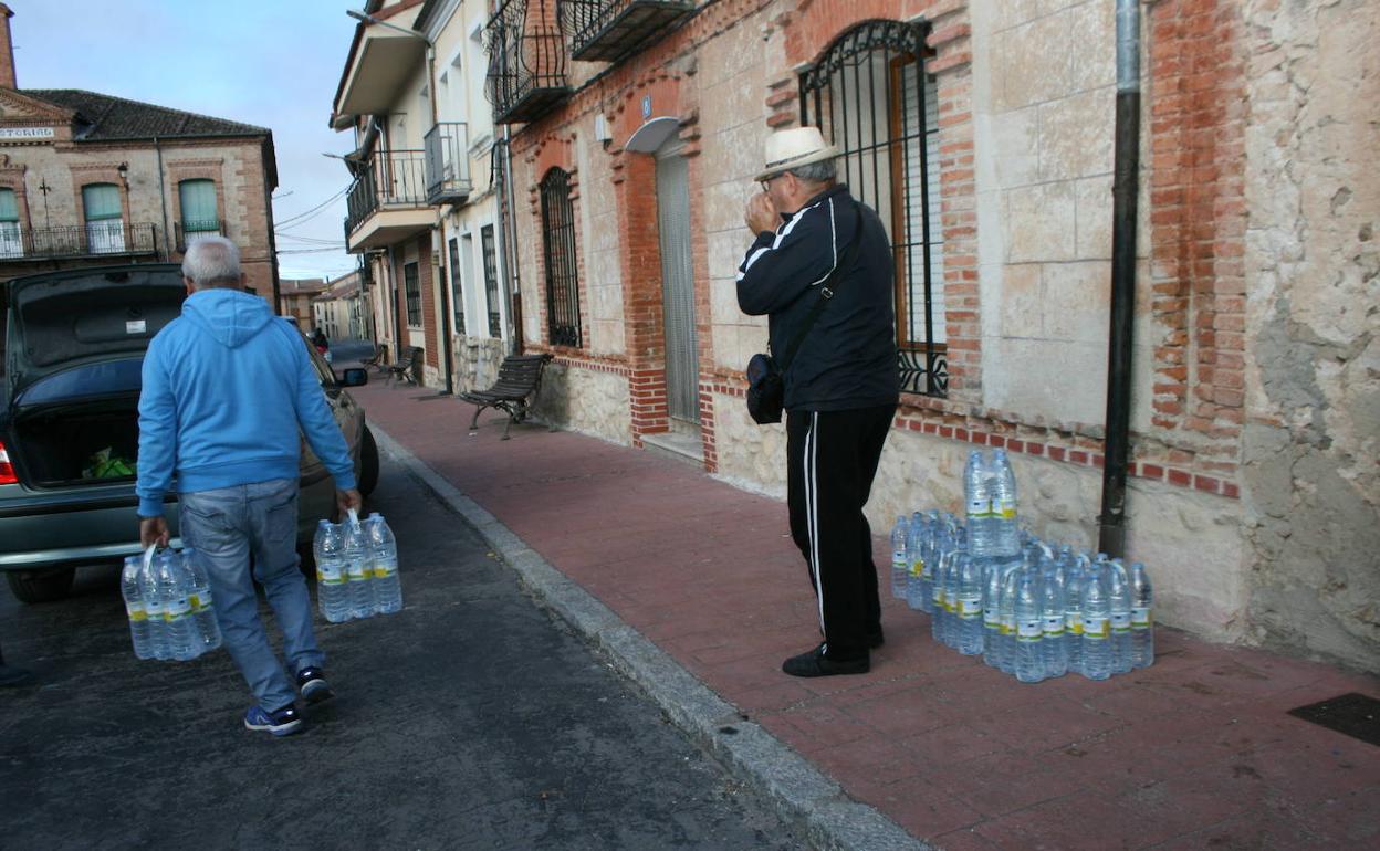 Un vecino con botellas de agua en una de las recogidas semanales.