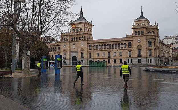 Tres soldados del regimiento Villaviciosa patrullan sobre el adoquinado mojado de la plaza de Zorilla.