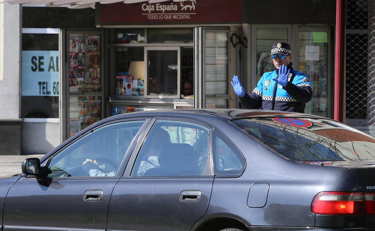 Un Policía Local para a un vehículo durante un control. 