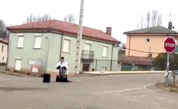 Momento en el que el cura desplazado a Barrillos se arrodilla en medio de la carretera para rezar.