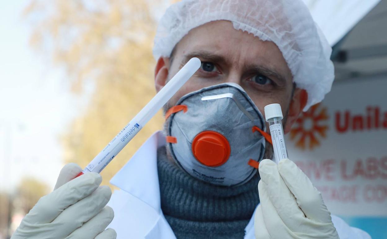 Un biólogo de Eylau Unilabs Analysis Laboratories muestra una muestra para detectar el virus en la unidad de detección del Covid-19