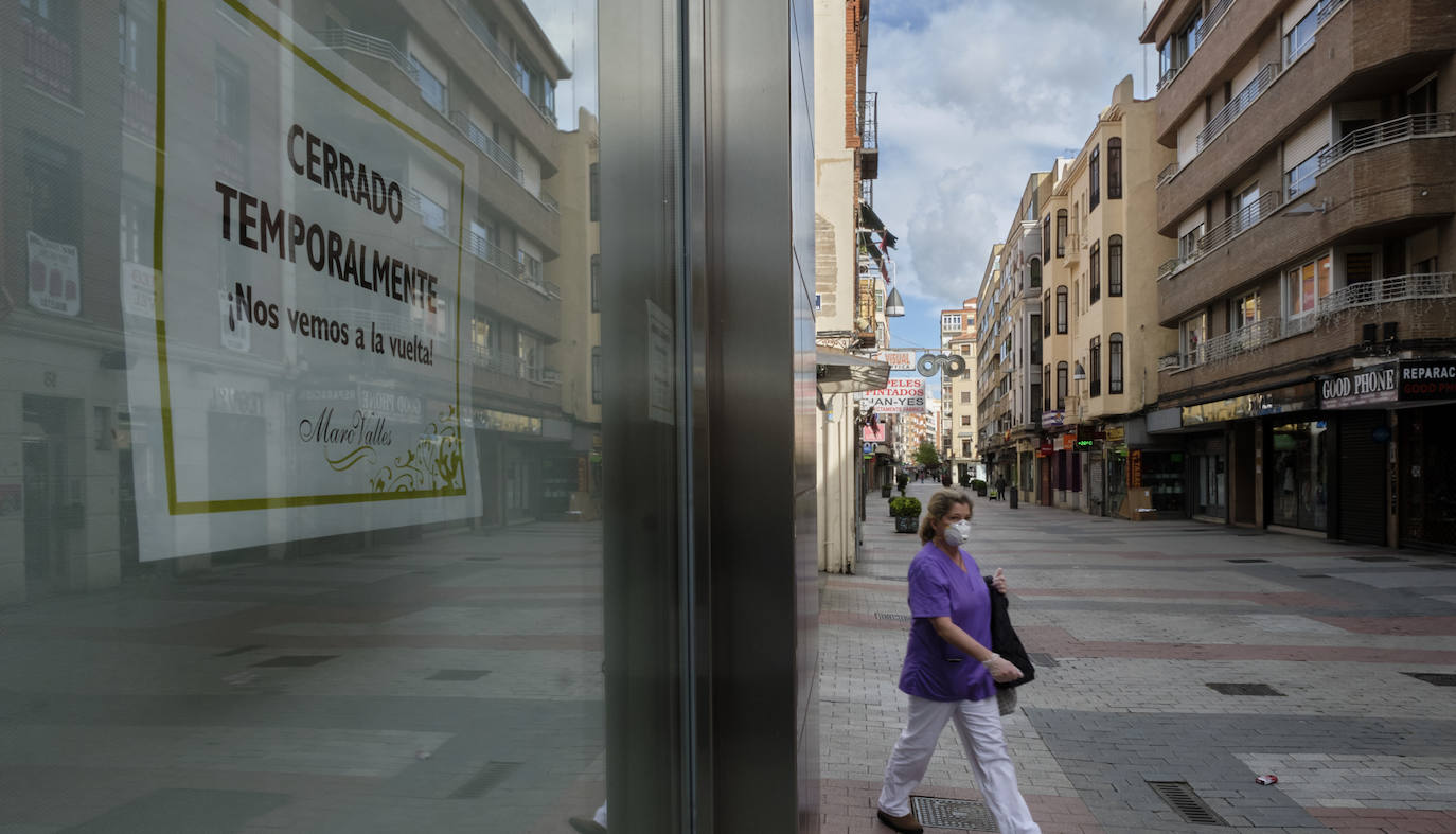 Una enfermera camina junto a un establecimiento cerrado en el centro de Valladolid. 