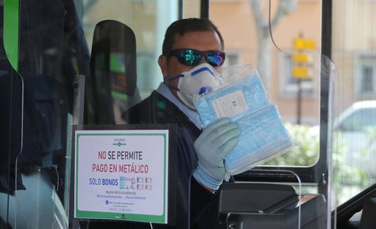 Un conductor de autobús, con las mascarillas que reparte. 