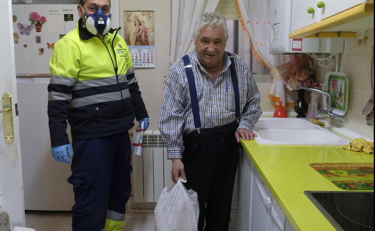 Un trabajador municipal entrega el servicio de catering a domicilio a un usuario de Valladolid. 