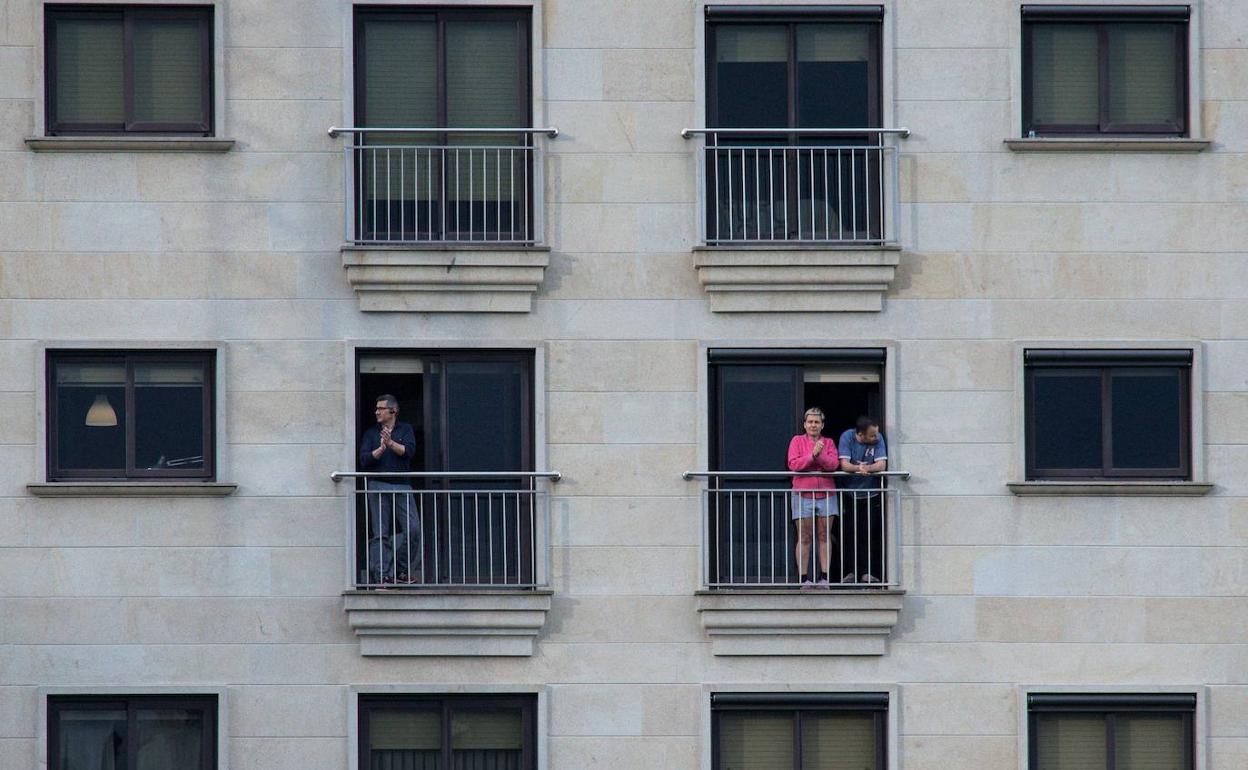 Varias personas aplauden desde el confinamiento en sus casas.