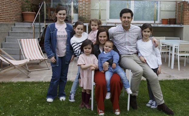 De izquierda a derecha, Macarena, Blanca, María, Paloma, Carmen, con Alfonso en brazos, Alfonso y Elena posan en el jardín de su casa. 