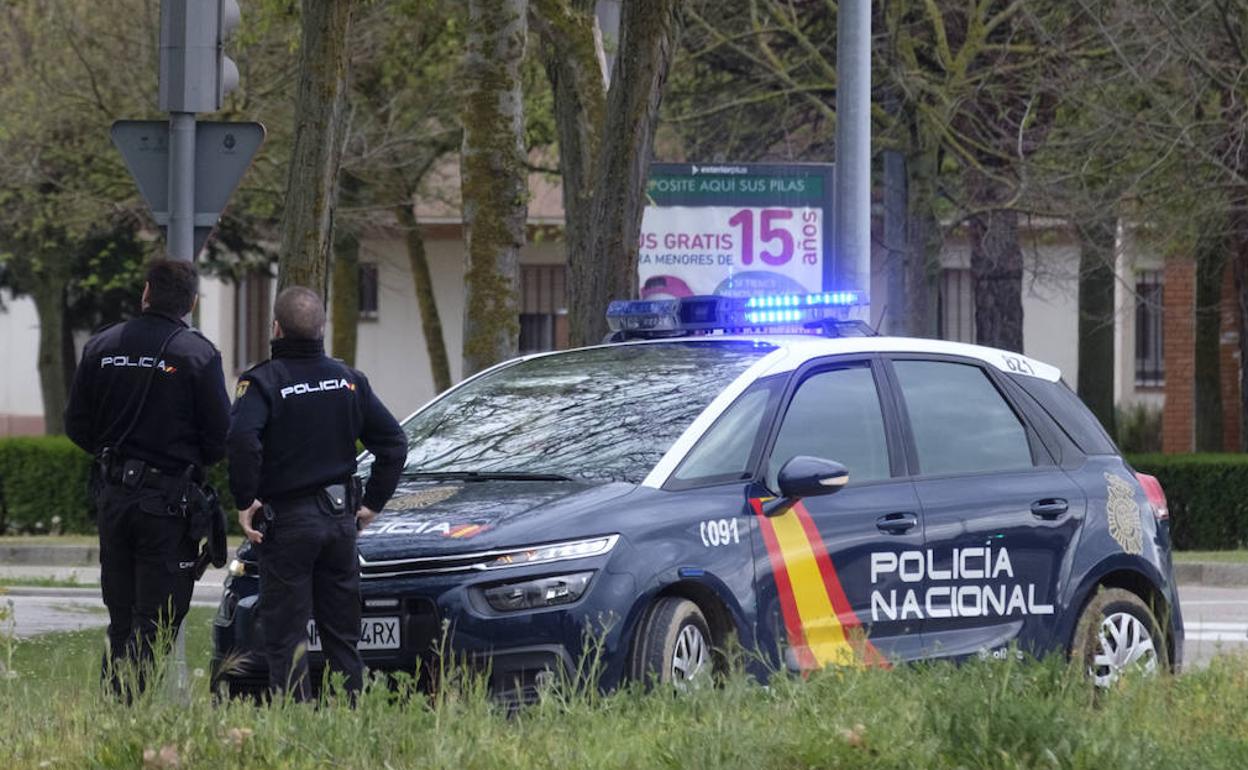 Agentes de la Policía Nacional, con un vehículo patrulla. 