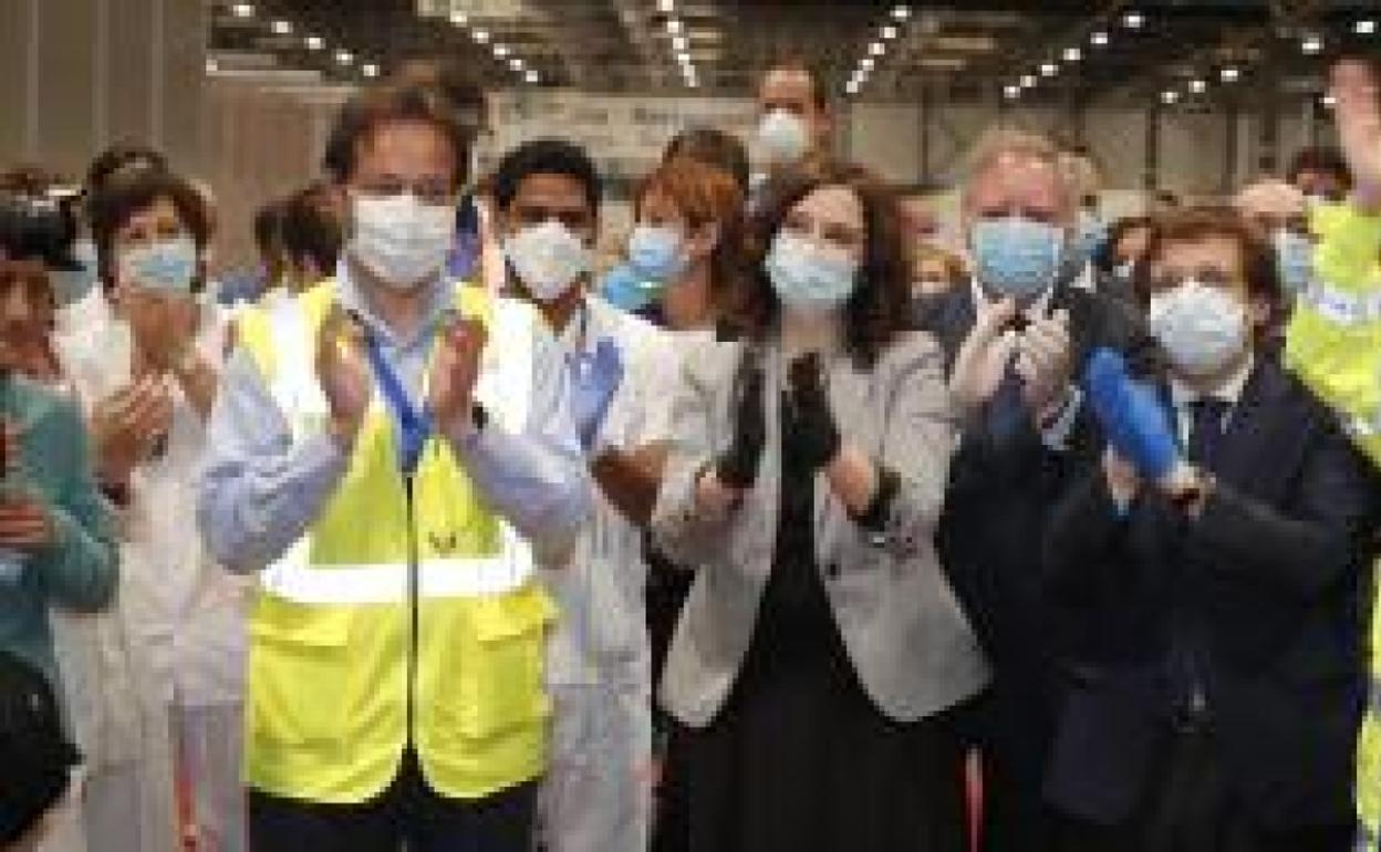 La presidenta de la Comunidad de Madrid, Isabel Díaz Ayuso, con el alcalde de Madrid a su derecha, José Luis Martínez-Almeida, en el acto de clausura del hospital de Ifema junto a las últimas pacientes en salir del recinto. 