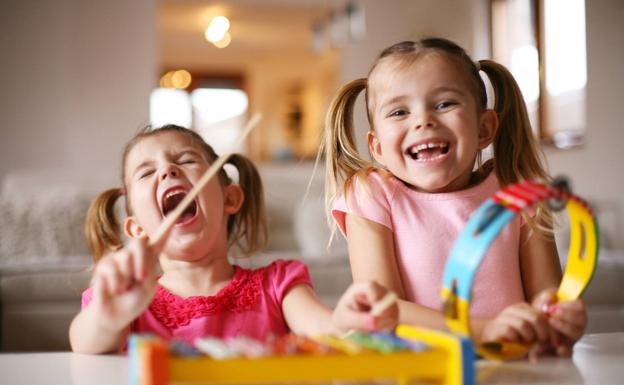 Dos niñas ríen durante una actividad de música. 