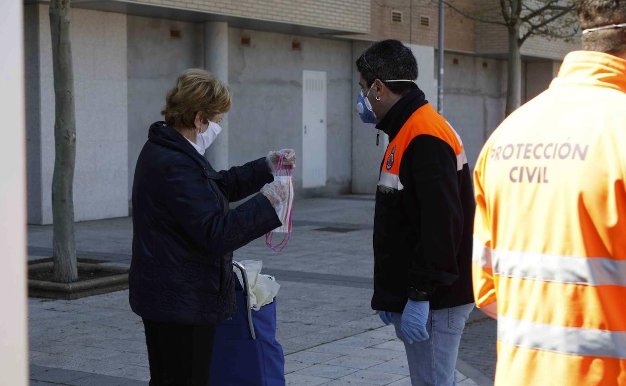 Una mujer recibe una mascarilla en las calles de Peñafiel