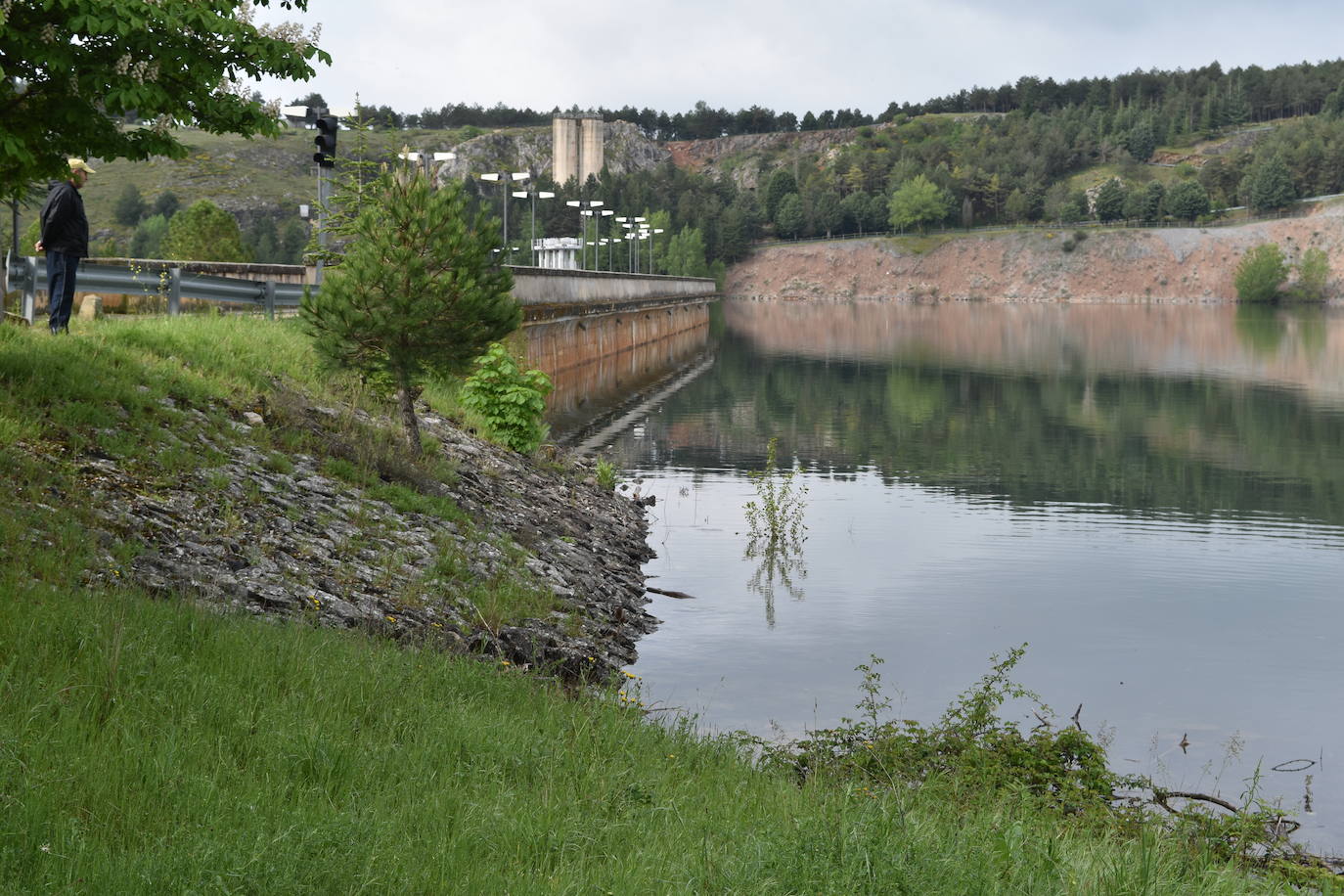 Un hombre contempla el embalse.