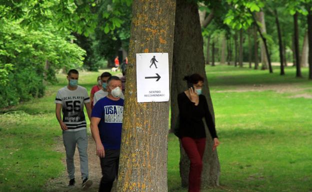 Huellas en aceras estrechas de sentido único para evitar aglomeraciones y carteles en la alameda del Parral