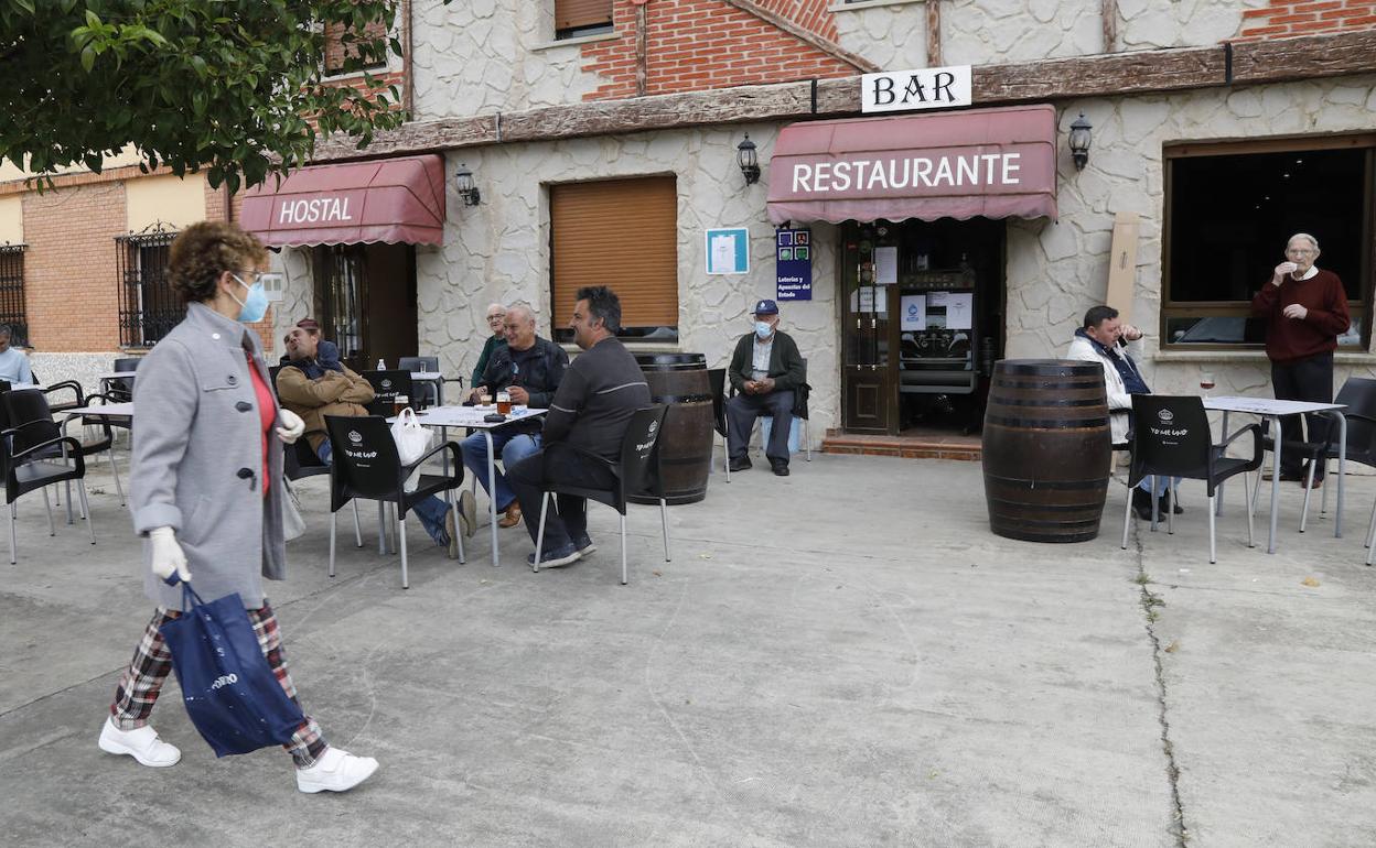 Una vecina de Torquemada pasa por delante de la terraza del hostal Carazo.