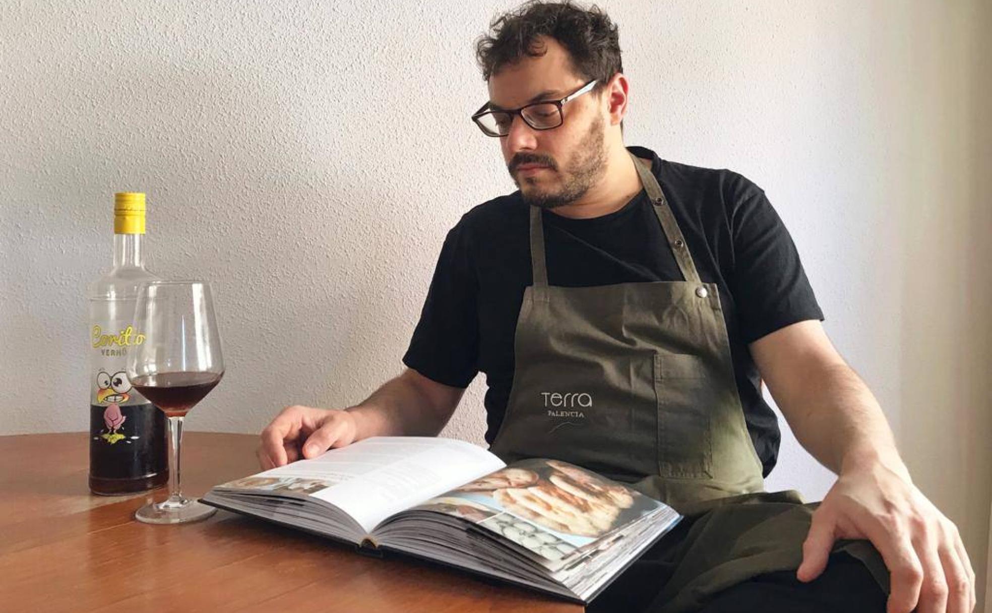 Roberto Terradillos disfruta de un vermú mientras lee un libro de recetas de panadería. 