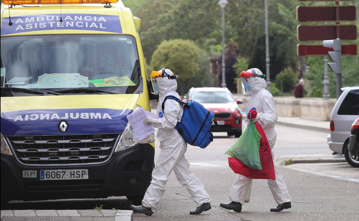 Un equipo sanitario porta material tras la atención en un domicilio, en el entorno del Puente Mayor. 