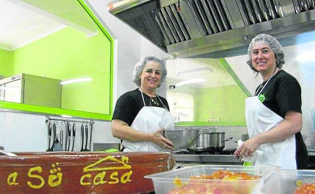 Eliecer Soto (derecha), en la cocina con una de sus empleadas. 