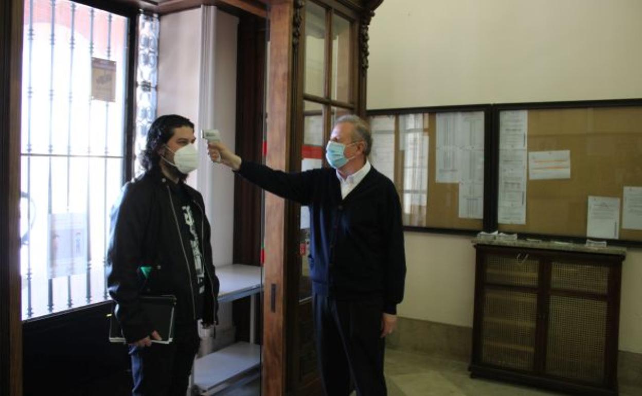 Un empleado del Ayuntamiento de Zamora toma la temperatura a un concejal. 