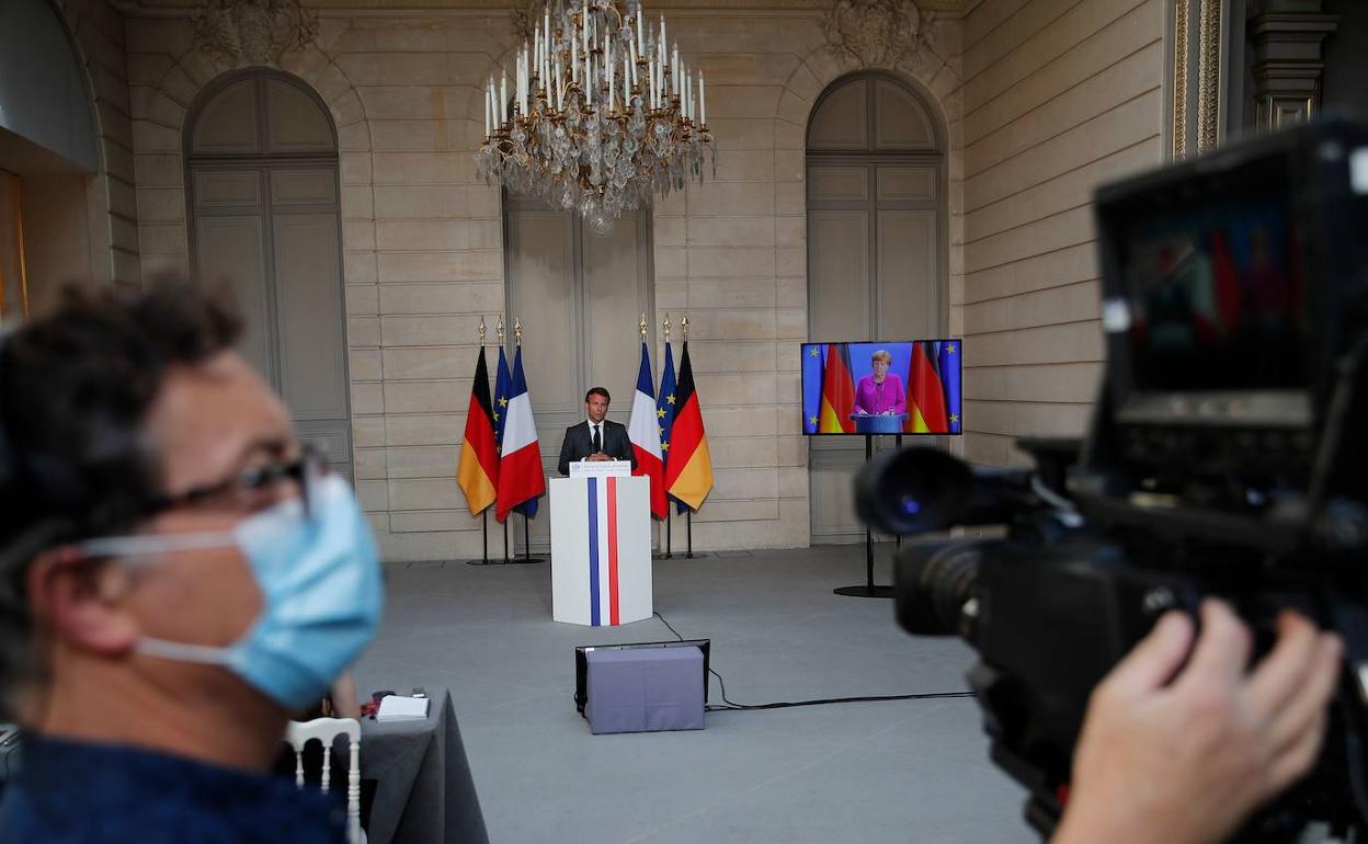 Un cámara ajusta su equipo en el Elíseo durante la videoconferencia entre Macron y Merkel.