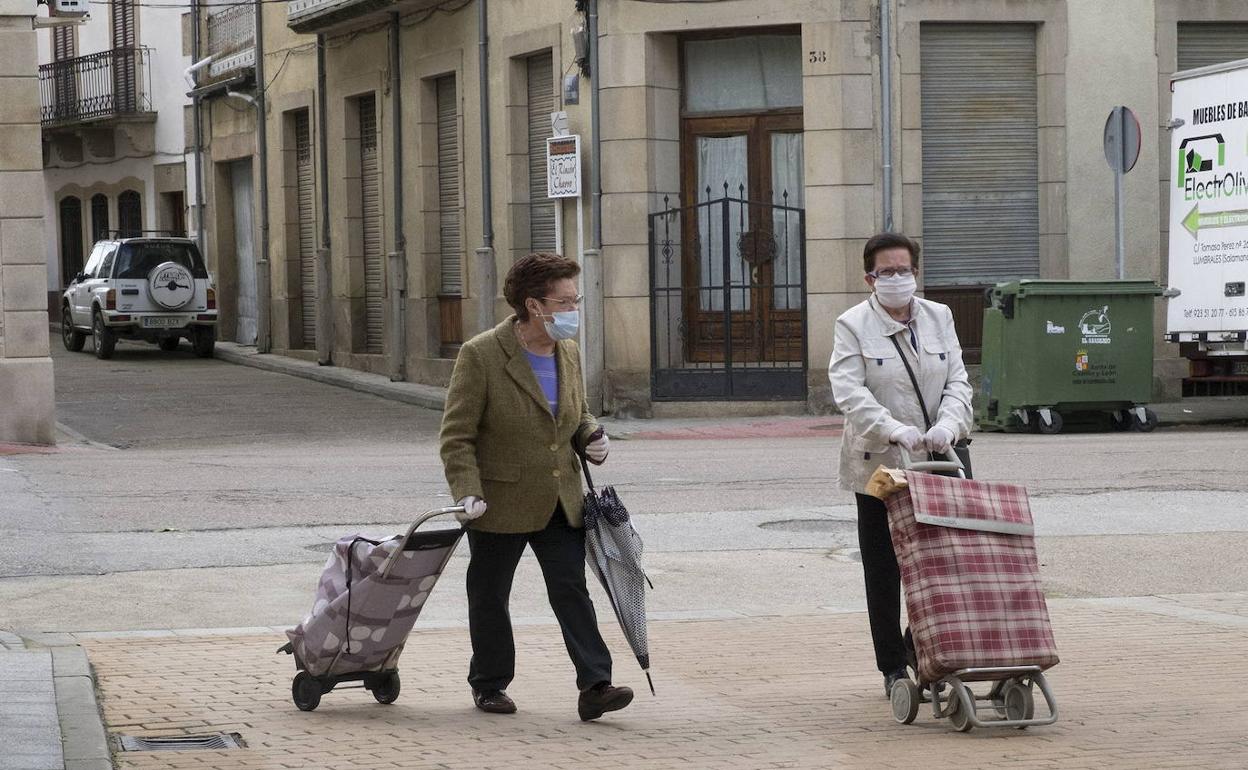 Dos mujeres acuden a la compra en Lumbrales. 