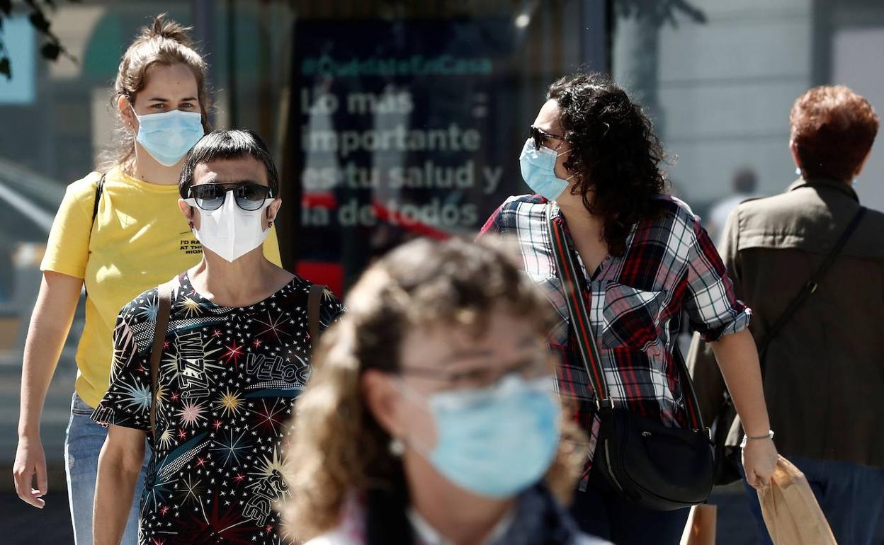 Un grupo de personas con mascarilla pasean por Pamplona.