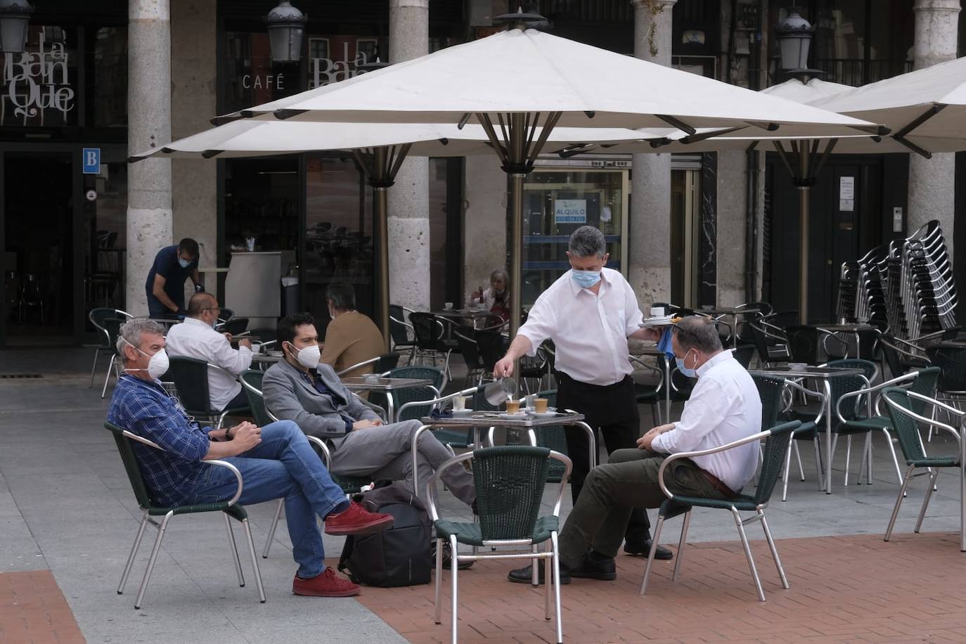 Un camarero sirve a unos clientes en una terraza de la Plaza Mayor 