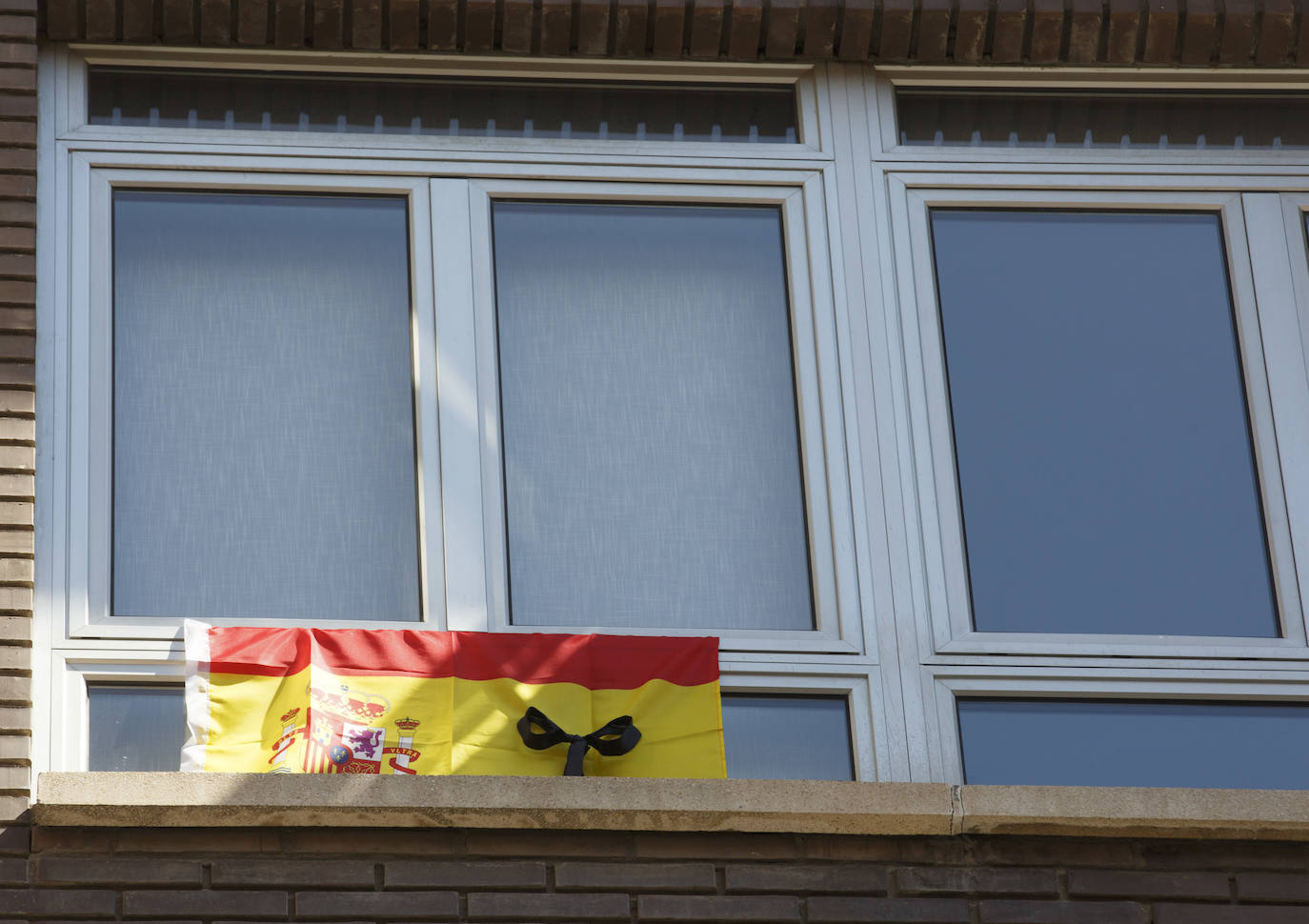 Los vallisoletanos han homenajeado hoy a las víctimas del coronavirus colocando en balcones y ventanas banderas de España y de Castilla y León con crespones negros. 