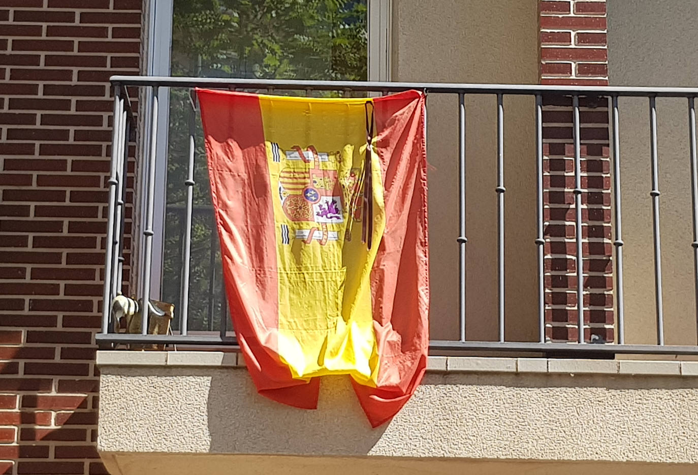 Los vallisoletanos han homenajeado hoy a las víctimas del coronavirus colocando en balcones y ventanas banderas de España y de Castilla y León con crespones negros. 