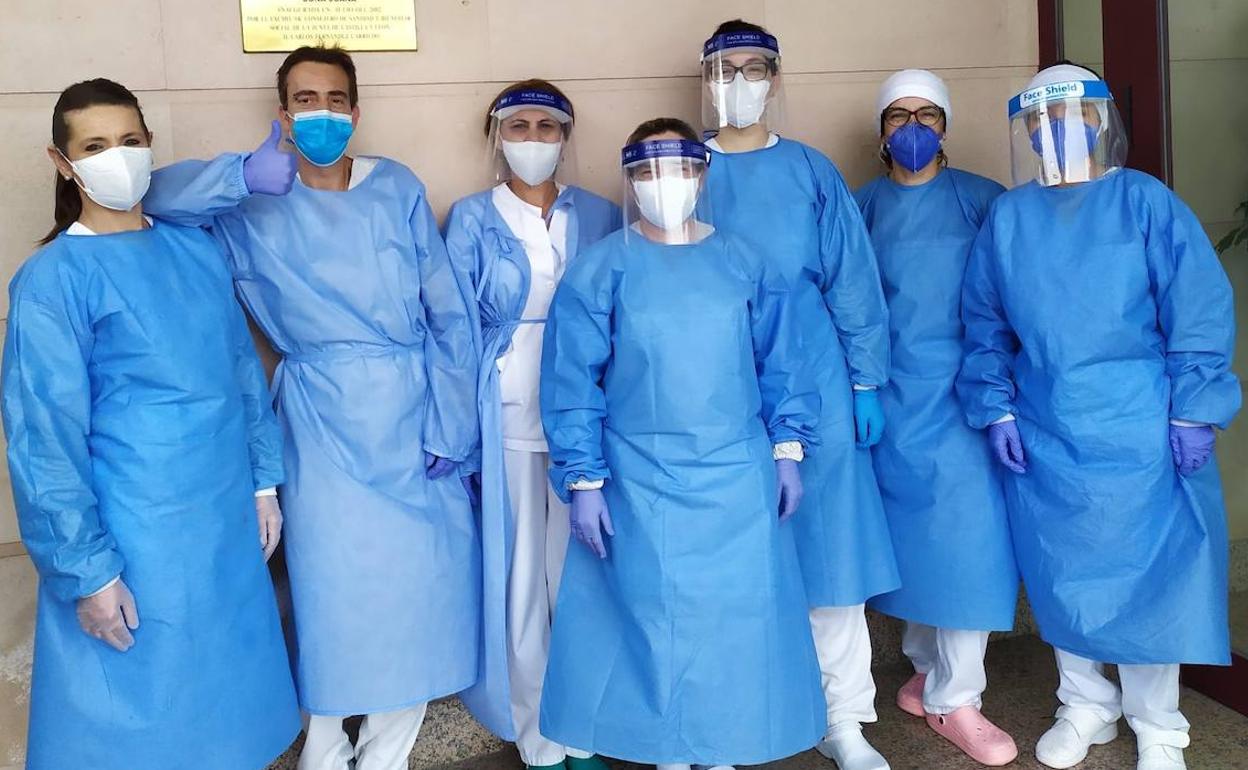 Un grupo de sanitarios posan con algunas de las batas cosidas por las voluntarias de Asa.