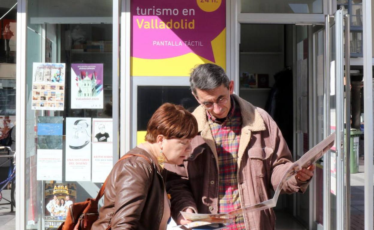 Dos turistas consultan el pasado mes de febrero un mapa junto a la oficina de turismo ubicada en la plaza de Fuente Dorada, en Valladolid. 