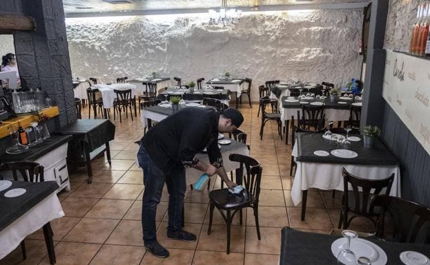 Alfonso Manzano desinfecta las sillas en el restaurante Caroba. 