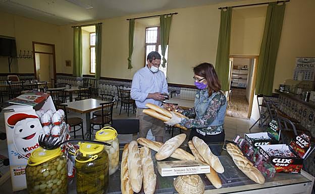 Sandra Rojas despacha el pan a un cliente en la parte del bar.