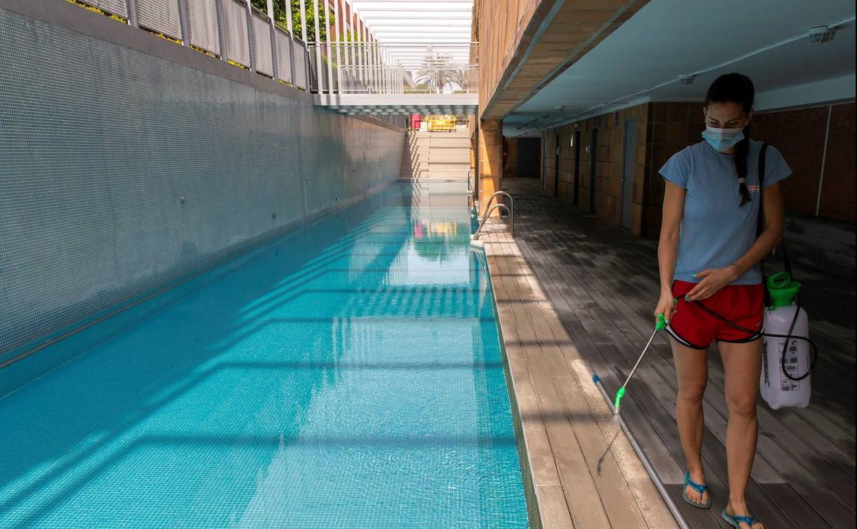 Una socorrista desinfecta una piscina comunitaria..