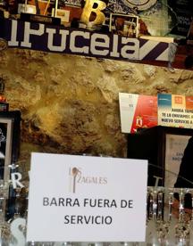 Imagen secundaria 2 - Arriba y abajo a la derecha, dos clientes en una mesa y el cartel en el que se explica que la barra está fuera de servicio por el momento en Los Zagales. Abajo a la izquierda, dos ciudadanos toman unas tapas en el Bar Mini Circular. 