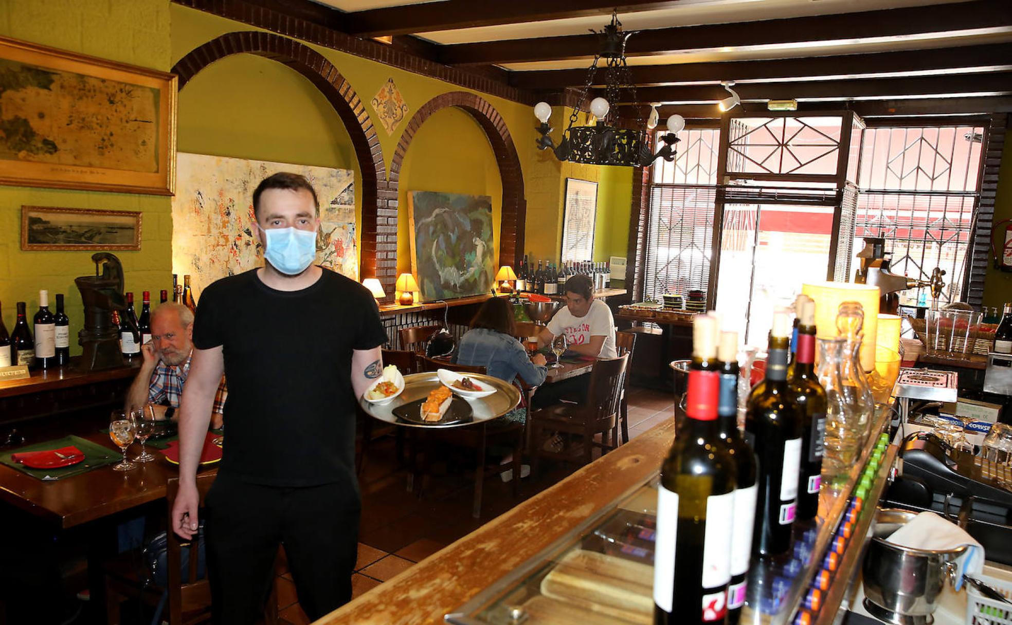 Pelayo, preparado para servir algunas de las tapas de El Pinchín en una de las mesas. 