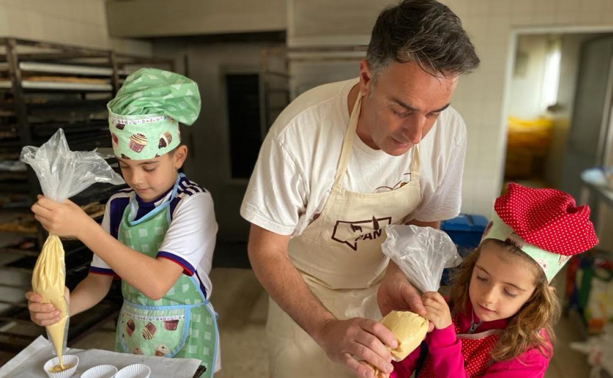 Izan y Olaya junto a su padre, Adolfo, preparando unas magdalenas. 