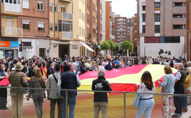 Un grupo de asistentes despliega una bandera de España al terinar el acto. 