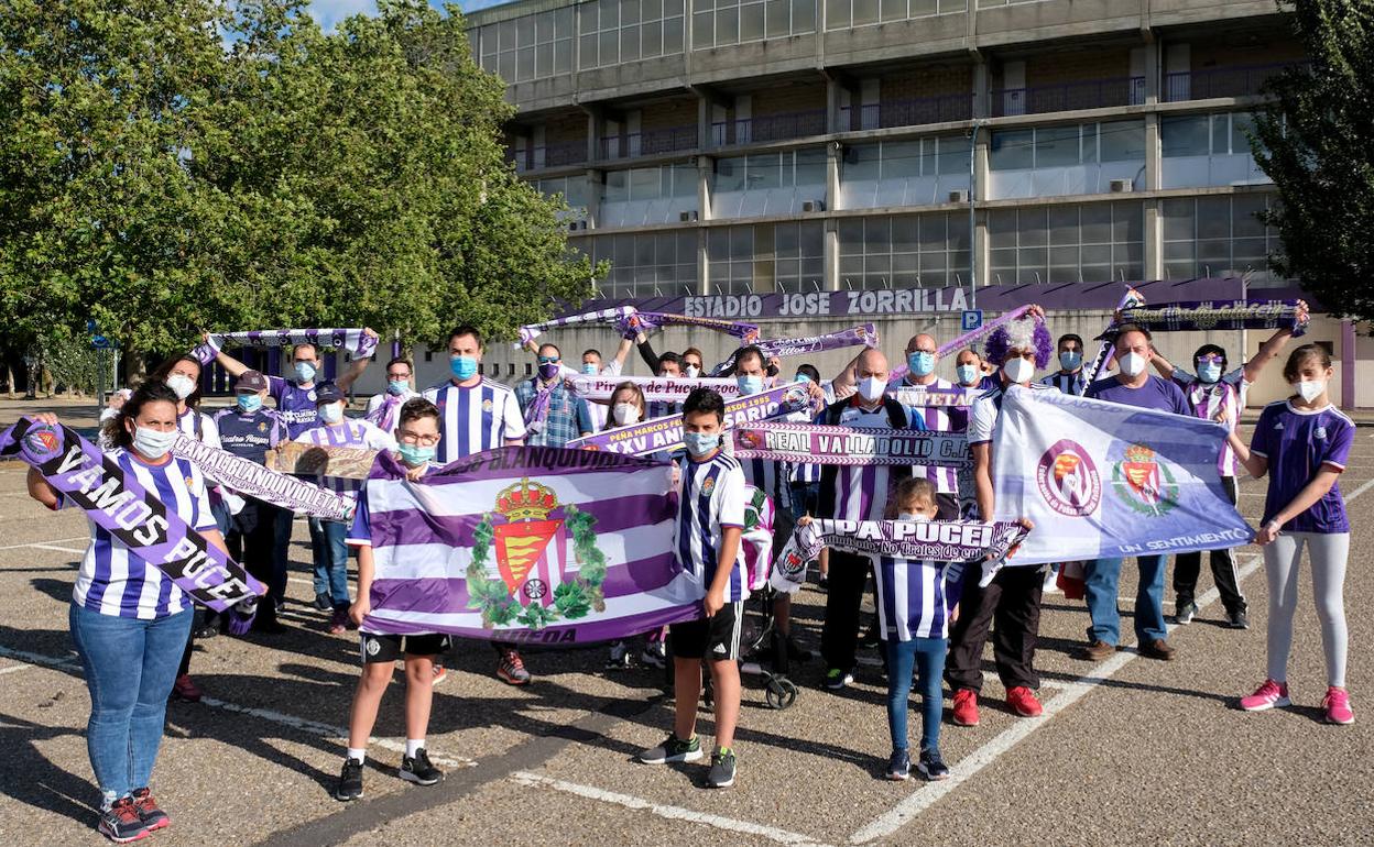 Representantes de las peñas presumen de colores en el aparcamiento del estadio ataviados con sus bufandas y camisetas blanquivioletas. 