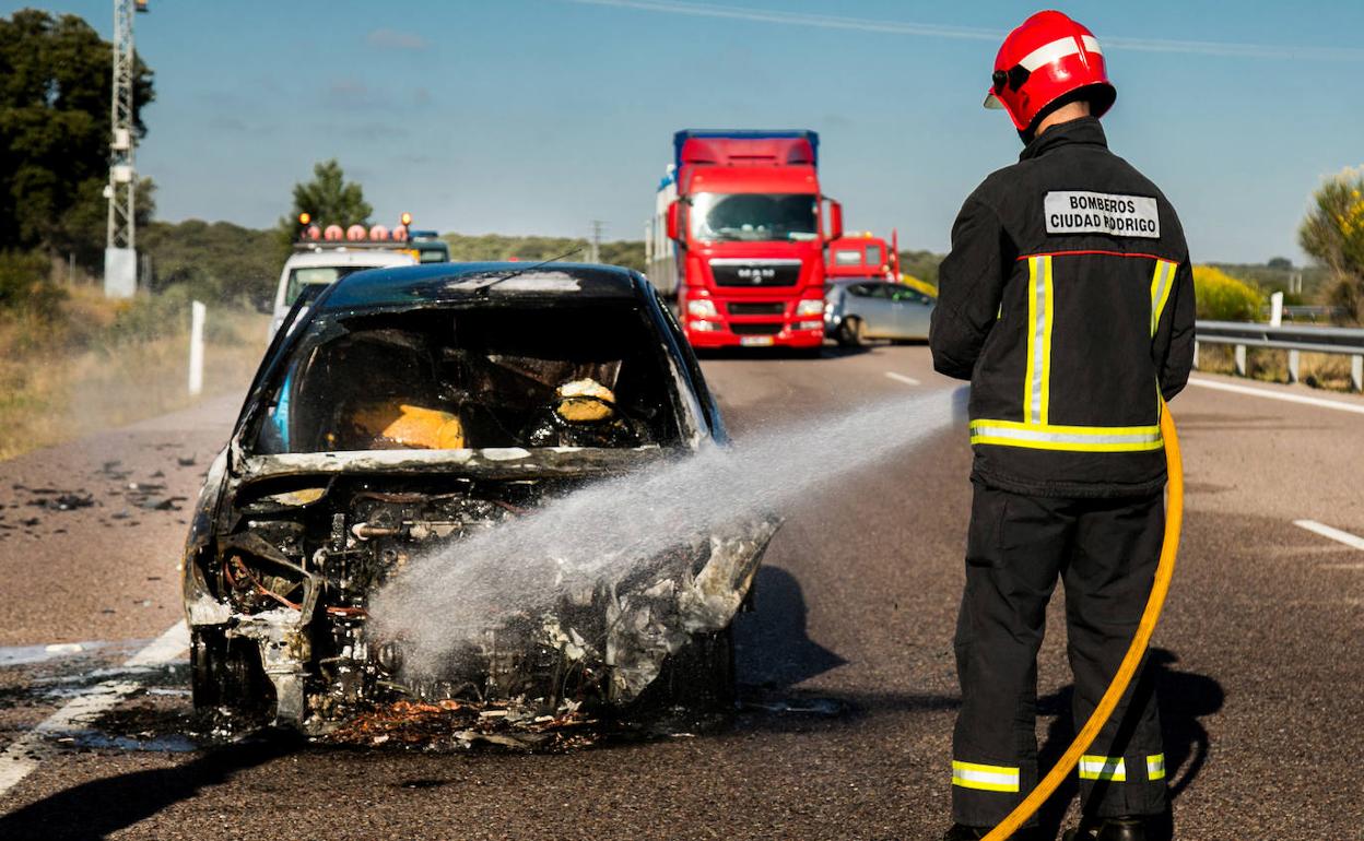 Bomberos de Ciudad Rodrigo sofocan un incendio en uno de los vehículos accidentados.