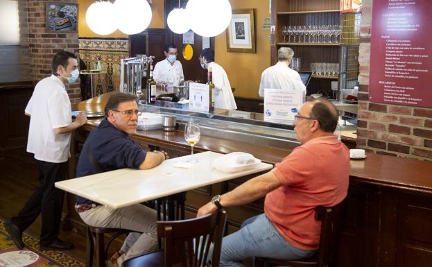 Imagen principal - El calor y el miedo a los espacios cerrados frustra el primer día de barra en los bares. 