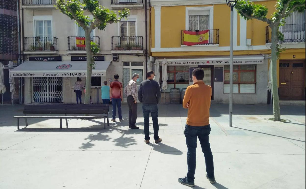 Vecinos de Tudela de Duero hacen cola para comprar el pan en la plaza de España