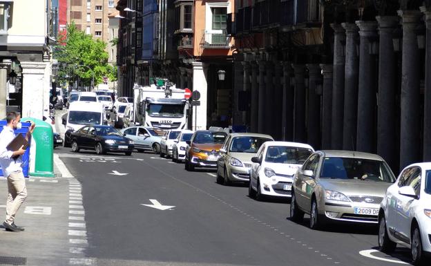 Imagen principal - Colas antes del cruce de la Bajada de la Libertad y la señal que prohíbe circular hacia Cánovas del Castillo (debajo a la izquierda). A la derecha, el carril bus en la plaza de Poniente.