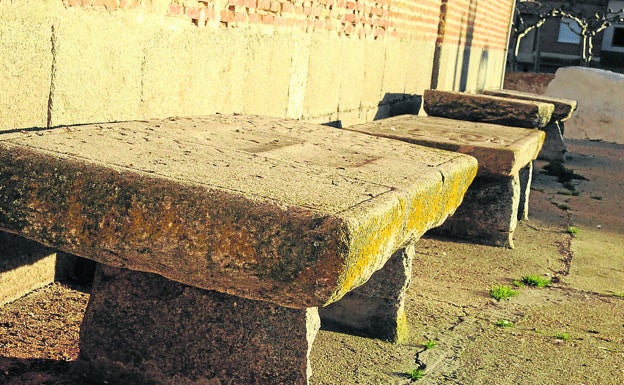 Imagen principal - Arriba, lápidas de piedra; pila bautismal y La torre de la Iglesia marca el perfil de la villa. 
