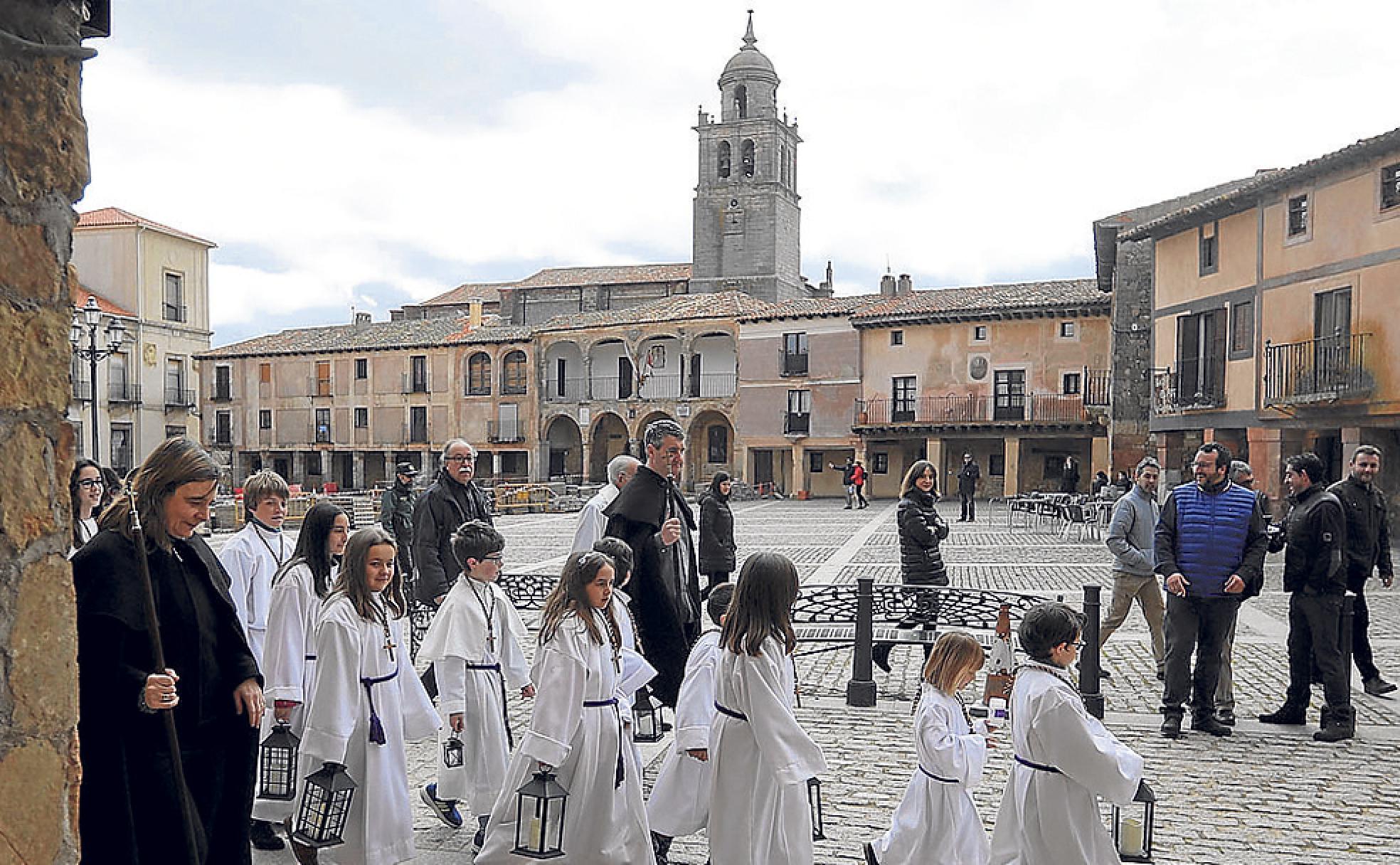 Algunos cofrades atraviesan la Plaza Mayor. Al fondo, el Ayuntamiento- 