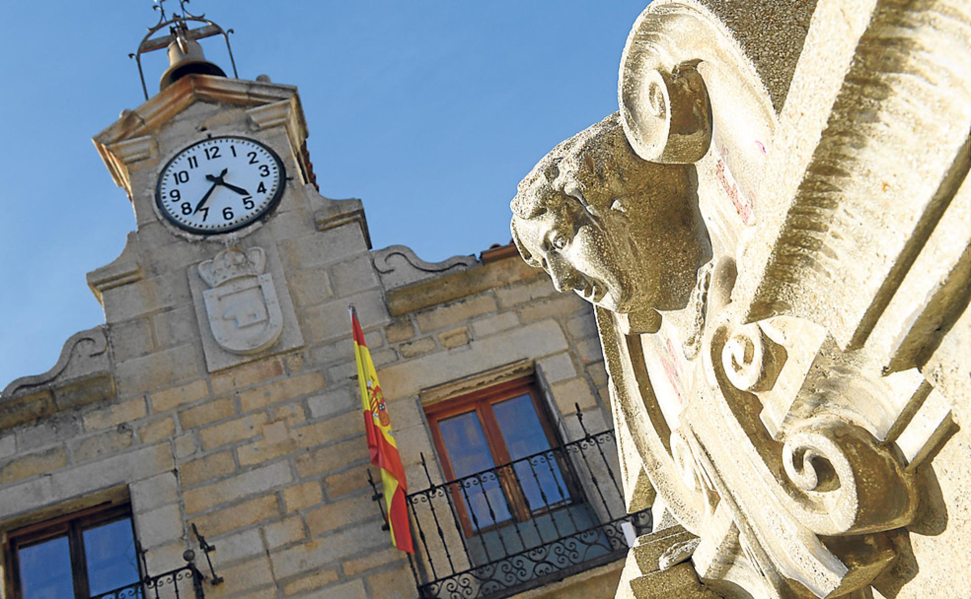 Reloj y escudo en la fachada de la casa consistorial de El Barraco.
