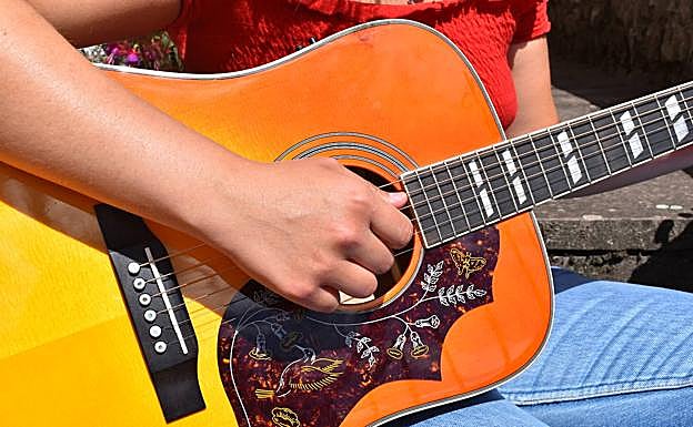 Las manos de Ana en la guitarra. 