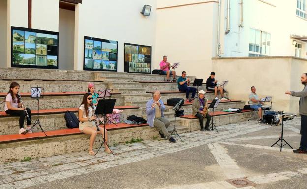 Imagen principal - Un ensayo de parte de los componentes de la Banda de Música cumpliendo las normas sobre distancia en uno de los patios del Museo del Cerrato. Abajo, las dos fachadas del Museo y a la derecha, el patio barroco del interior del edificio más antiguo de los dos que forman este espacio, el antiguo hospital. 