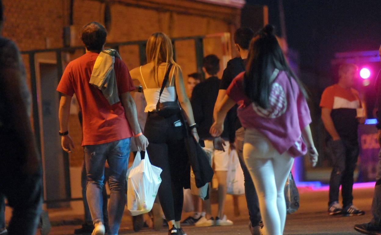 Varios jóvenes con bolsas de bebida para organizar un botellón, en una imagen de antes de la pandemia. 