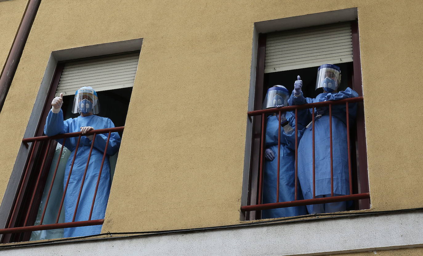 Auxiliares de la residencia Nuestra Señora del Carmen, en Valladolid, se asoman a una ventana durante el estado de alarma.