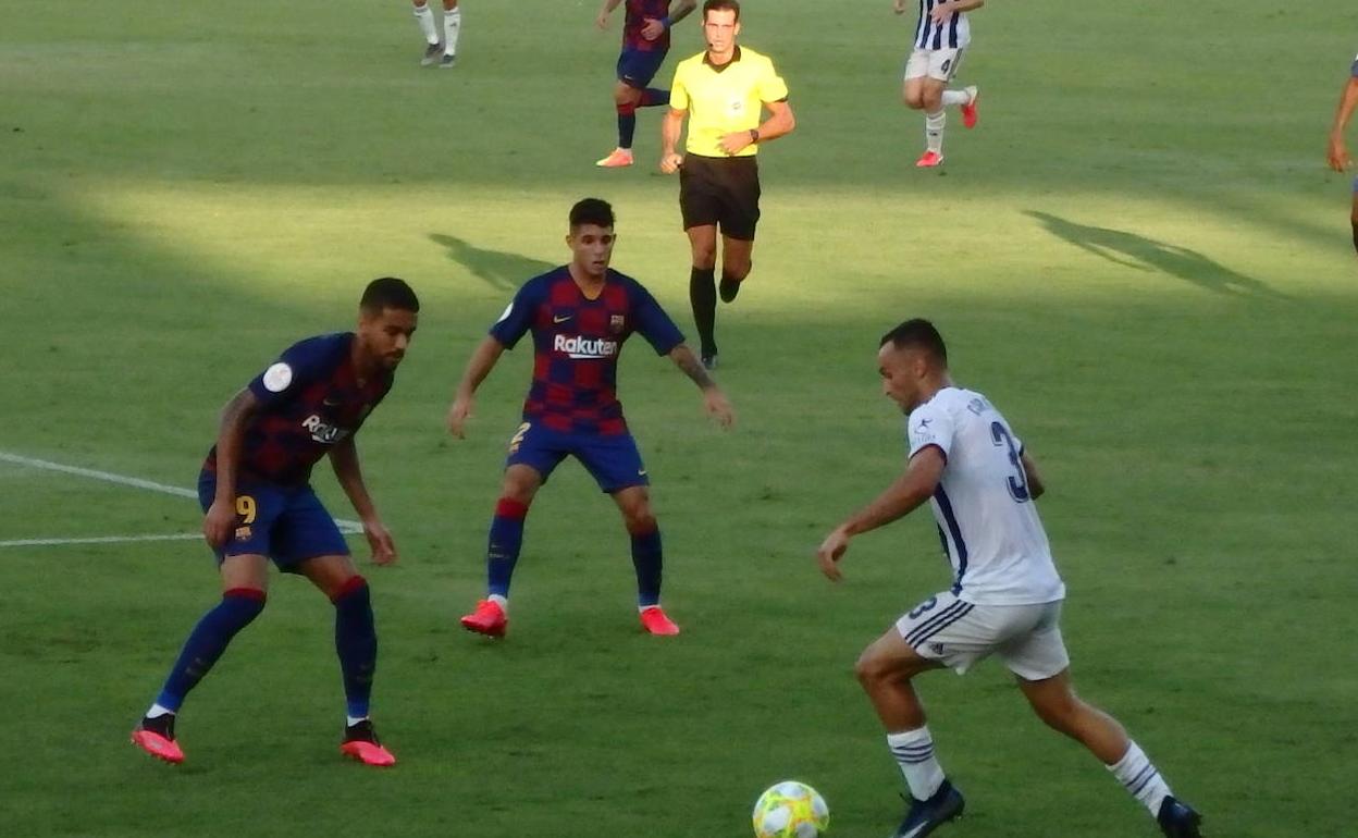 Corral encara a dos rivales ante la presencia del colegiado. 